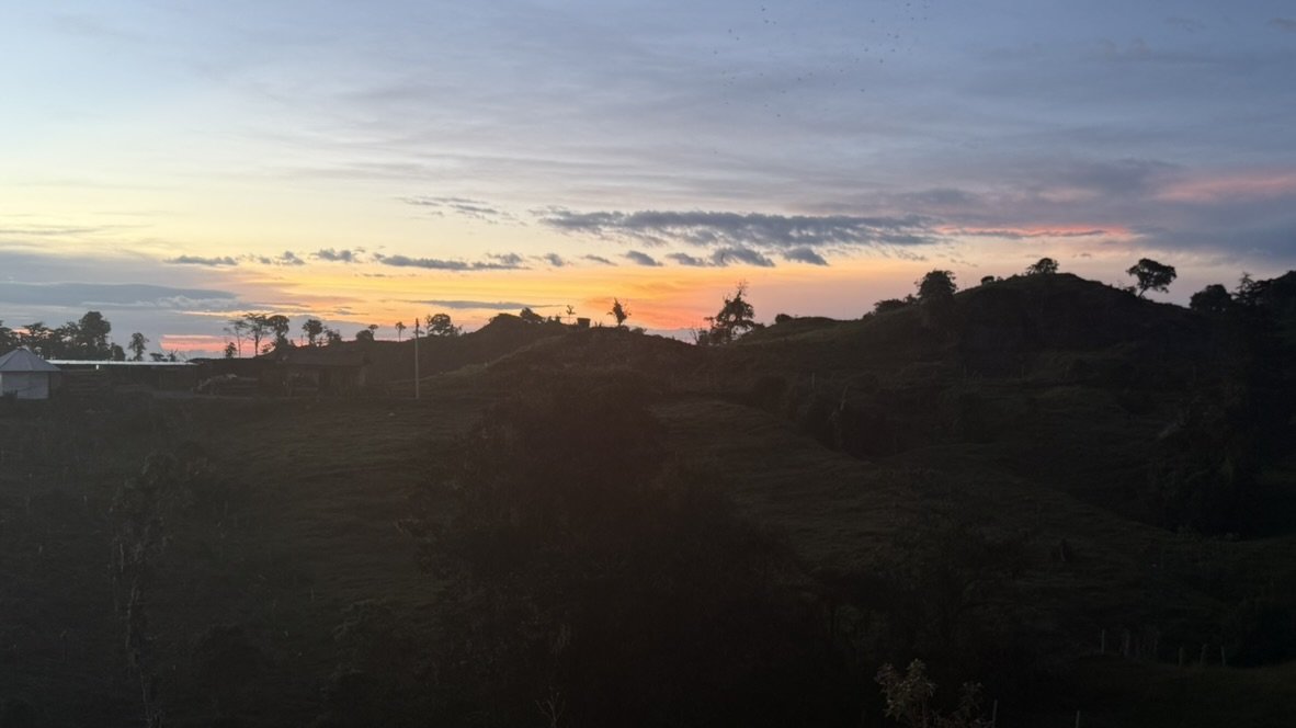 Atardecer naranja sobre las colinas y potreros de El Peñón, Santander, visto desde la finca Los Clavellinos